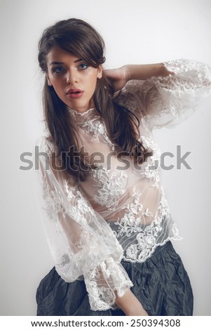 A photo of beautiful girl is in fashion style.Beautiful  woman with elegant dress posing in studio. Fashion photo