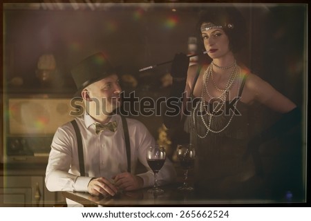 Retro couple.Couple with glasses of red wine in restaurant.Fashion,retro, vintage, tones. Antique picture with scratches and film grain.