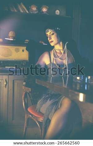 Retro girl with glasses of red wine in restaurant.Fashion,retro, vintage, tones. Antique picture with scratches and film grain.