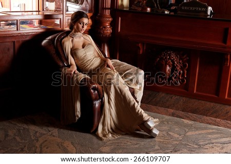 Glamour lady portrait in luxury dress. Beautiful model girl with perfect fashion makeup and hairstyle. Eelegant girl, in a luxury interior.