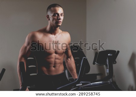 Stationary bicycles fitness man in a gym sport club. Close up.