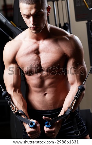 Very power athletic guy, execute exercise in sport hall. Closeup of a muscular young man lifting weights.