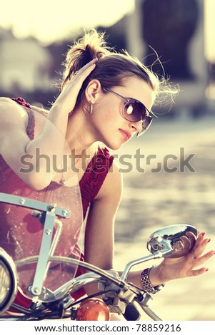 Portrait of smiling girl on scooter  - Outdoor on street .Retro shot. Fashion art photo