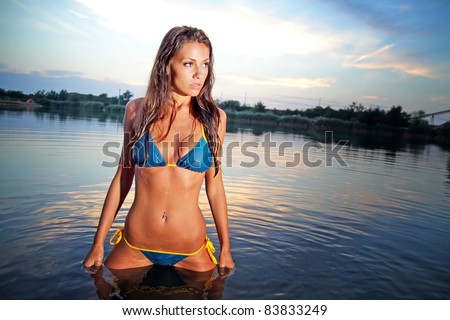 Sexy girl in bikini posing at sunset