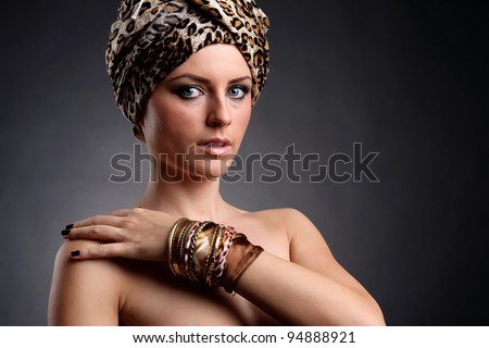 A beautiful arabian blonde woman posing in a studio wearing jewelry.