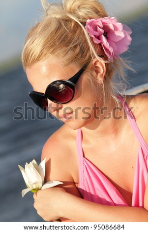 Beautiful blonde woman relaxing at the sunset in a boat.