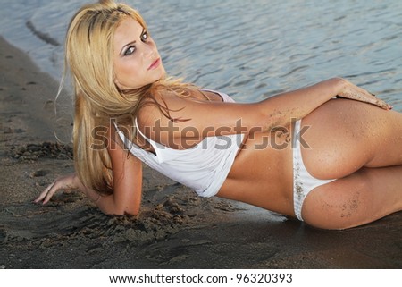The beautiful model posing against a setting sun on a body of water