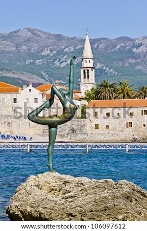 Dancing Girl Statue - an attractive sculpture and popular photo opportunity for tourists on background of old city Budva, Montenegro, Europe. Statue is located near road which leads to beach Mogren