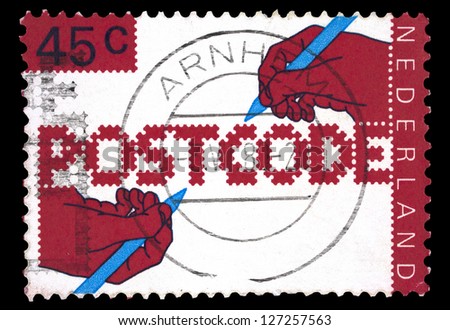 NETHERLANDS - CIRCA 1978: A stamp printed in Netherlands shows hands that write Postcode, with the inscription 