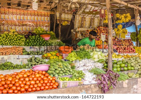 GOA, INDIA - SEPTEMBER 26, 2013: Unknown seller of fruits and vegetables in a small market in Vagator, Goa. Vegetables, fruits and seafood is one of the main part of Indian peoples ration.