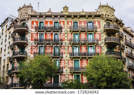 Beautiful building facade. Old style windows, balcony and painting. Barcelona. Spain