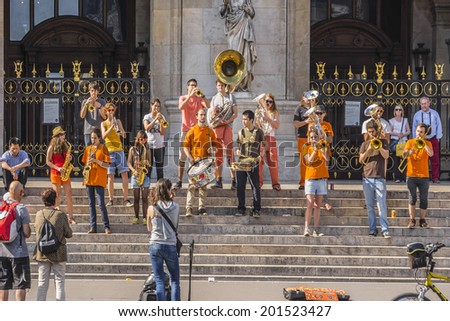 PARIS, FRANCE - MAY18, 2014: Young brass band near Paris Opera building (Garnier Palace) in Paris. Dozens buskers perform on the streets and in Paris metro.
