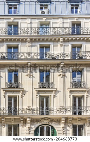 Traditional French house with Typical balconies and windows. Paris, France.