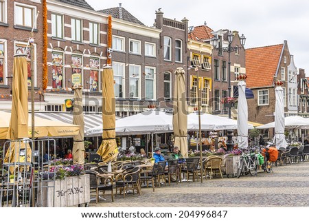 DELFT, NETHERLANDS - JUNE 17, 2013: Old houses, stores and restaurant on the Markt (central square) of Delft, Holland.