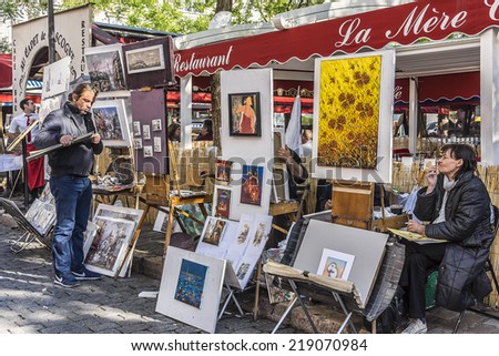 PARIS, FRANCE - MAY 15, 2014: Artists easels and artwork set up in Place du Tertre in Montmartre. Montmartre attracted many famous modern painters in the early 20th century.