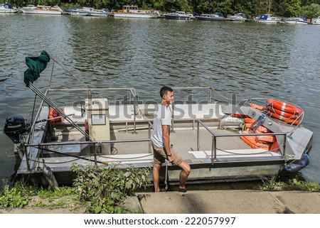 TWICKENHAM, UK - JUNE 4, 2013: Small ferry transports people between the banks of River Thames near Twickenham. Twickenham is a town on River Thames, England in London Borough of Richmond upon Thames.