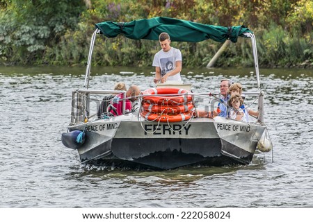 TWICKENHAM, UK - JUNE 4, 2013: Small ferry transports people between the banks of River Thames near Twickenham. Twickenham is a town on River Thames, England in London Borough of Richmond upon Thames.