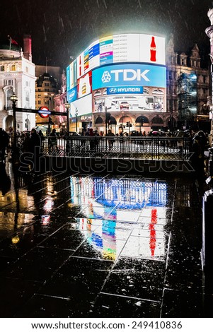 LONDON, UK - MARCH 17, 2013: Famous Piccadilly Circus neon signage shines at rainy night. These signs have become a major attraction of London, United Kingdom.