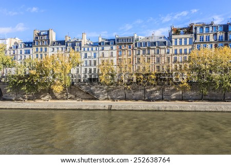 The picturesque embankments of the river Seine in autumn. Paris, France. Buildings, trees and river.