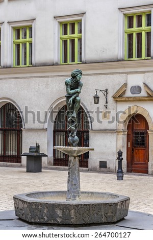 A bronze statue of a poor student near St Mary\'s Basilica - a replica of Wit Stwosz (German sculptor, Veit Stoss) sculptures in famous gothic altar of Basilica (Kosciol Mariacki). Kracow, Poland.