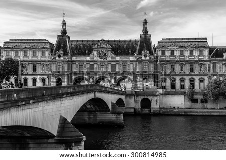 PARIS, FRANCE - MAY 30, 2015: View of famous Louvre Museum from the Seine River. Louvre Museum is one of the largest and most visited museums worldwide. Black and white.