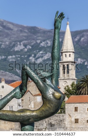 BUDVA, MONTENEGRO - MAY 1, 2012: Dancing Girl Statue - an attractive sculpture and popular photo opportunity for tourists on background of old city Budva.