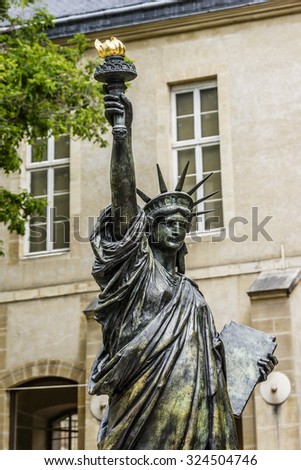 PARIS, FRANCE - JUNE 6, 2015: Museum of Arts and Crafts (1794) houses collection of National Conservatory of Arts and Industry is a museum of technological innovation. Statue of Liberty near entrance.