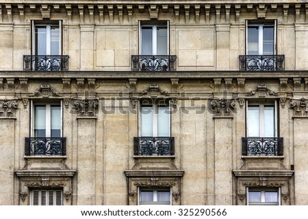 Traditional French house with typical balconies and windows. Paris, France.