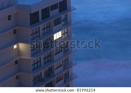 Early Morning Concept - A Building with Light in only One Window