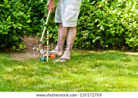Playing Croquet : Man getting ready to hit ball with mallet
