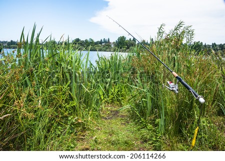 Recreational Fishing Rod by Lake. Copy space.