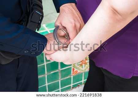 Under Arrest : Law enforcement officer handcuffing woman. Detail. Close up.
