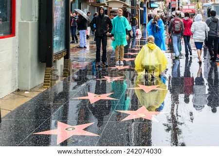 HOLLYWOOD, CA - DEC 12: Tourists taking pictures of stars on a rainy day on Hollywood Boulevard Walk of Fame, Hollywood, Los Angeles, California, Dec 12, 2014.