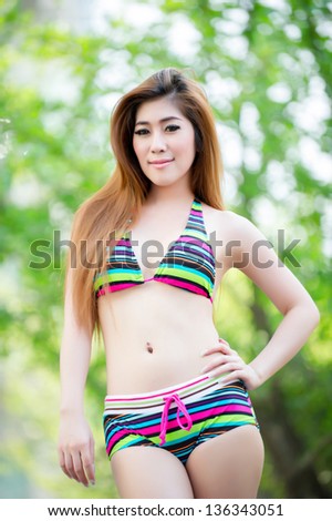 Beautiful asian woman in bikini at pool