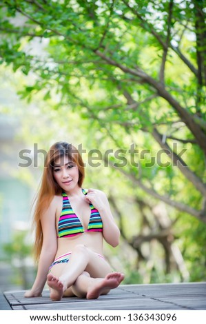 Beautiful asian woman in bikini at pool