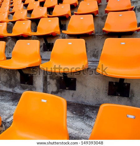 Orange empty stadium seats in arena