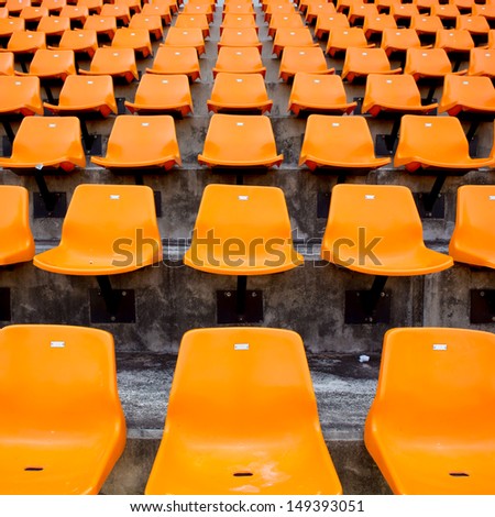 Orange empty stadium seats in arena