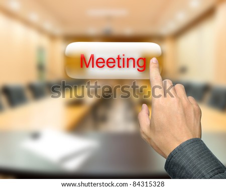 Male hand pressing meeting button on meeting room background