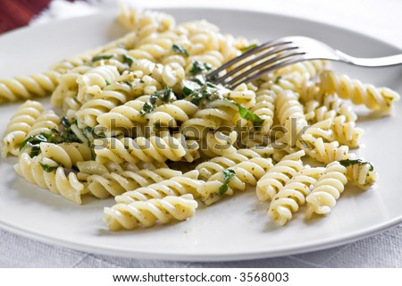 Fusilli with pesto sauce. A typical italian dish. Picking up with a fork.