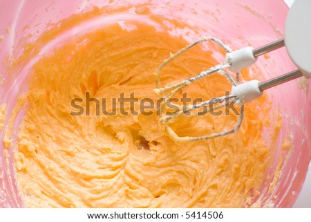 Preparing a cake. Stirring a cake mix with wire whiskes. Close-up.