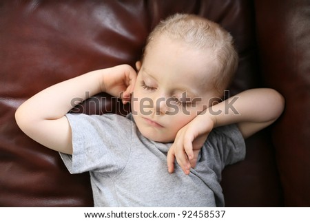 Child sleeping on a leather couch