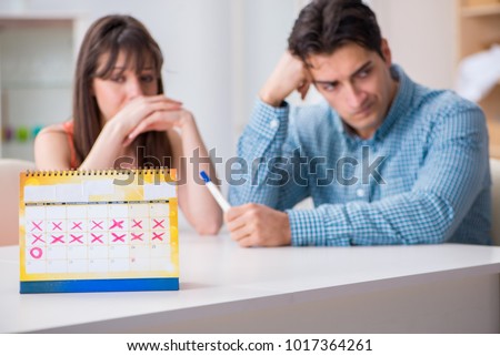 Young family in pregnancy planning concept with ovulation calendar