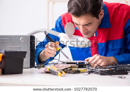 Professional repairman repairing computer in workshop