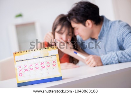 Young family in pregnancy planning concept with ovulation calend