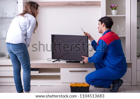 Tv repairman technician repairing tv at home