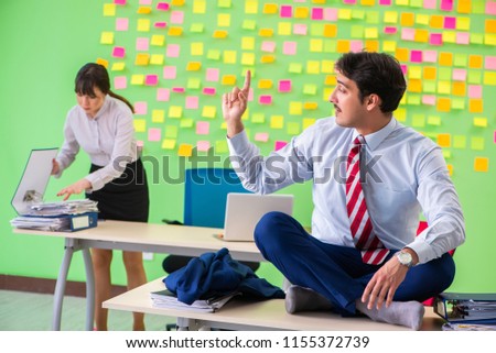 Man and woman in the office with many conflicting priorities in