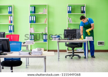 Male handsome professional cleaner working in the office