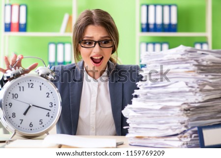 Young female employee very busy with ongoing paperwork in time m