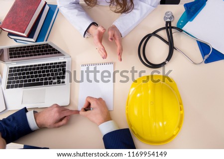 Doctor and manager agreeing industrial insurance coverage