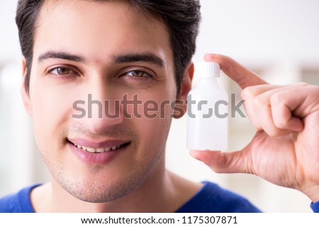Young handsome man taking care of face skin